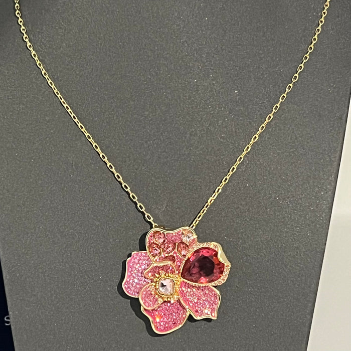 Swarovski Idyllia Pink Crystal Flower Pendant / Necklace  
 Color: Gold-tone chain with layered pink, magenta, and clear crystal pavé petals accented by a prominent deep-pink pear-cut crystal
