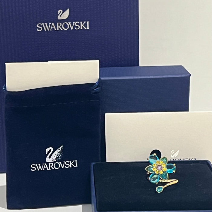 Swarovski Idyllia Blue Flower Ring 
 Color: Vibrant turquoise blue with a central purple crystal and yellow accent crystals (Left) / Shades of green, olive, and yellow with small pink crystal accents (Right
