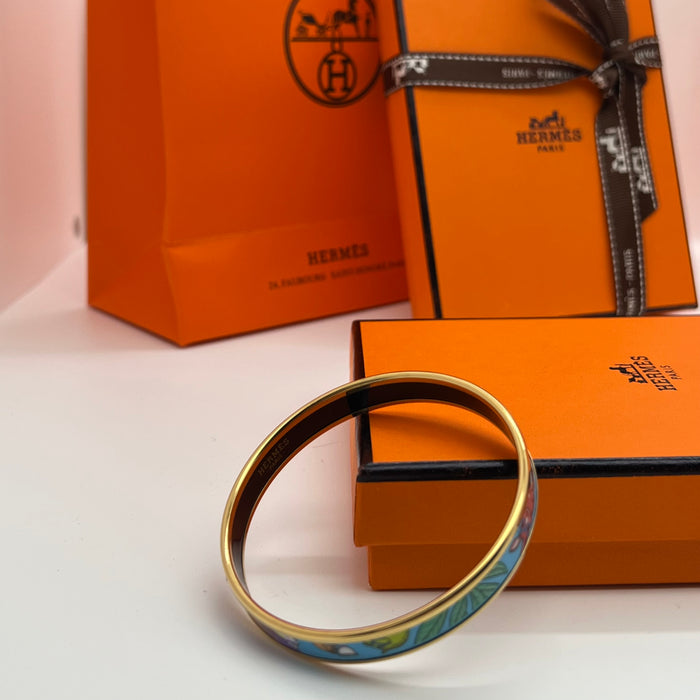 Hermès Enamel Bangle Bracelet
 Color: Light mint green/blue(off-white  background with black, grey, blue, and brown illustrations; black interior lining; gold trim)
