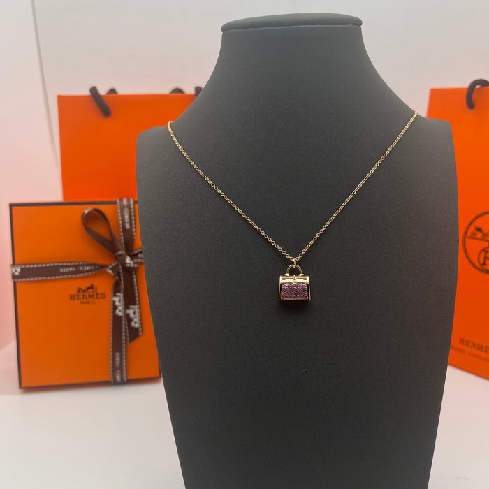Hermès Amulettes Kelly Pendant Necklace  
 Color: Gold with Purple crystal/rose gold with purple crystal