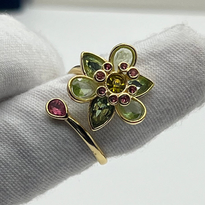 Swarovski Idyllia Blue Flower Ring 
 Color: Vibrant turquoise blue with a central purple crystal and yellow accent crystals (Left) / Shades of green, olive, and yellow with small pink crystal accents (Right