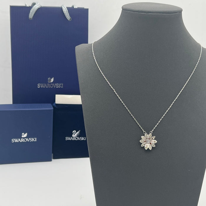 Swarovski Idyllia Daisy / Sunflower Pendant Necklace  
 Color: Silver-tone with pale yellow/champagne pavé petals, a central clear crystal, and contrasting amber-orange crystal accents
