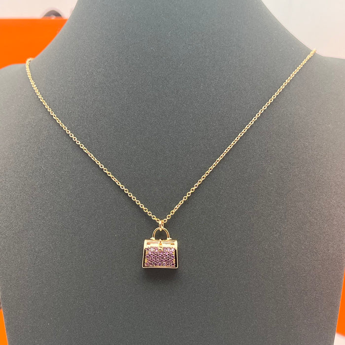 Hermès Amulettes Kelly Pendant Necklace  
 Color: Gold with Purple crystal/rose gold with purple crystal