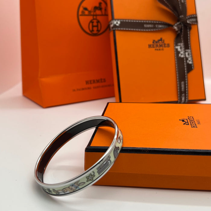 Hermès Enamel Printed Narrow Bangle / Bracelet  
 Color: Multicolor printed motif (light green/mint,/light blue/(powder blue, lilac/purple, soft yellow, and grey) with silver-tone rim and black inner lining