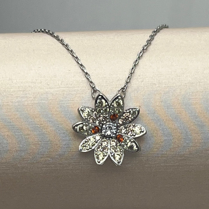 Swarovski Idyllia Daisy / Sunflower Pendant Necklace  
 Color: Silver-tone with pale yellow/champagne pavé petals, a central clear crystal, and contrasting amber-orange crystal accents