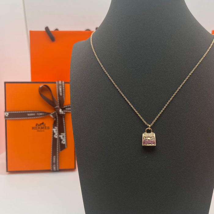 Hermès Amulettes Kelly Pendant Necklace  
 Color: Gold with Purple crystal/rose gold with purple crystal