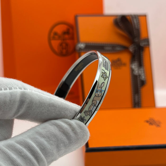 Hermès Enamel Printed Narrow Bangle / Bracelet  
 Color: Multicolor printed motif (light green/mint,/light blue/(powder blue, lilac/purple, soft yellow, and grey) with silver-tone rim and black inner lining