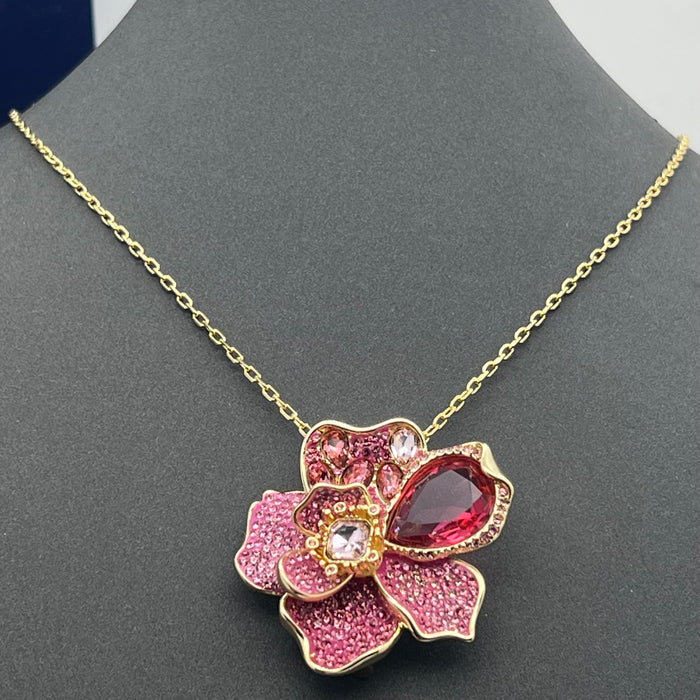 Swarovski Idyllia Pink Crystal Flower Pendant / Necklace  
 Color: Gold-tone chain with layered pink, magenta, and clear crystal pavé petals accented by a prominent deep-pink pear-cut crystal