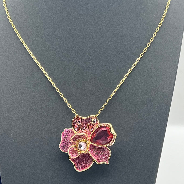Swarovski Idyllia Pink Crystal Flower Pendant / Necklace  
 Color: Gold-tone chain with layered pink, magenta, and clear crystal pavé petals accented by a prominent deep-pink pear-cut crystal