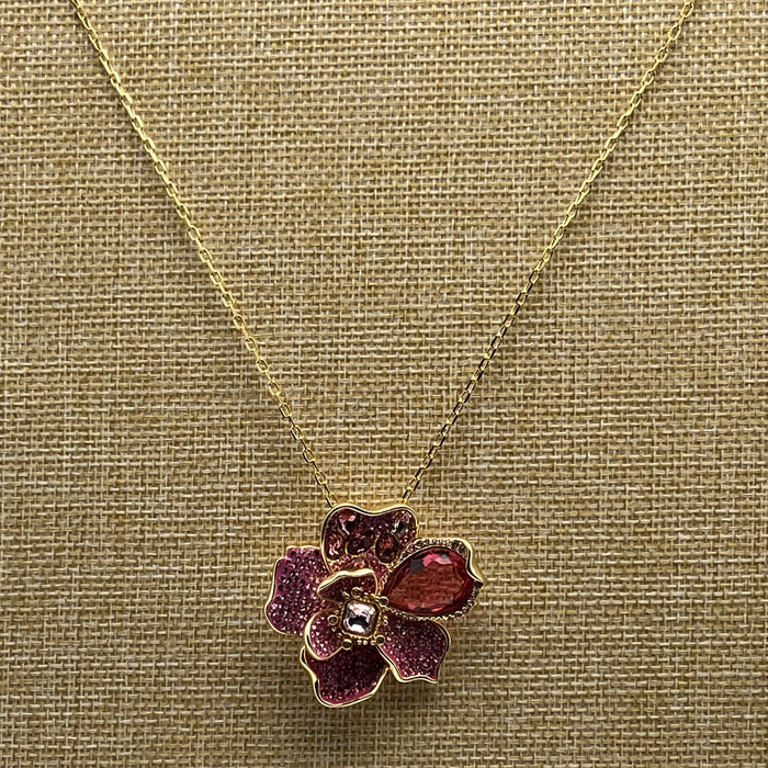 Swarovski Idyllia Pink Crystal Flower Pendant / Necklace  
 Color: Gold-tone chain with layered pink, magenta, and clear crystal pavé petals accented by a prominent deep-pink pear-cut crystal