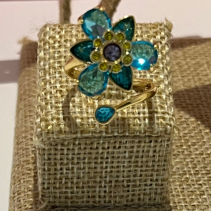 Swarovski Idyllia Blue Flower Ring 
 Color: Vibrant turquoise blue with a central purple crystal and yellow accent crystals (Left) / Shades of green, olive, and yellow with small pink crystal accents (Right