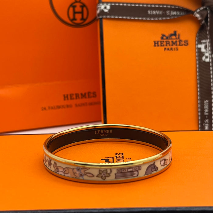 Hermès Enamel Bangle Bracelet
 Color: Light mint green/blue(off-white  background with black, grey, blue, and brown illustrations; black interior lining; gold trim)