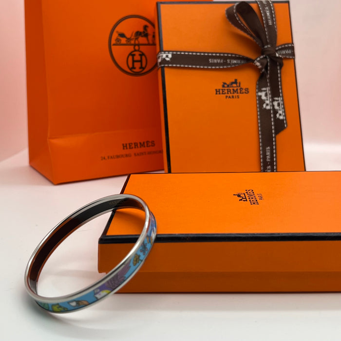 Hermès Enamel Printed Narrow Bangle / Bracelet  
 Color: Multicolor printed motif (light green/mint,/light blue/(powder blue, lilac/purple, soft yellow, and grey) with silver-tone rim and black inner lining