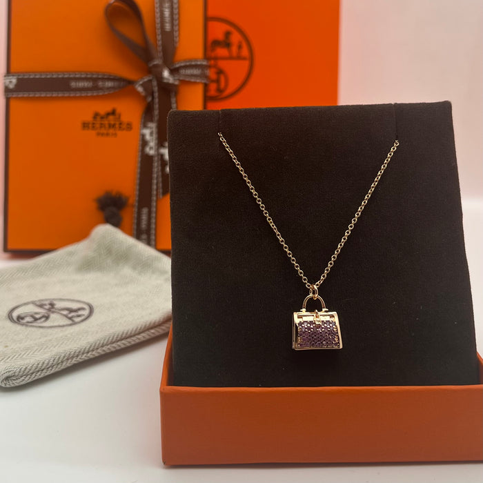 Hermès Amulettes Kelly Pendant Necklace  
 Color: Gold with Purple crystal/rose gold with purple crystal